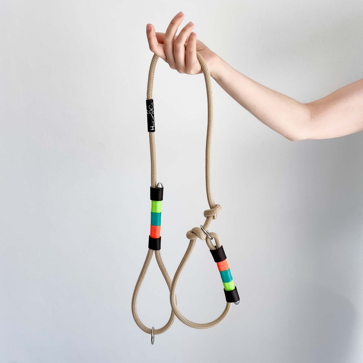 Ceres slip lead held in a hand, natural rope with lime, teal and coral whipping